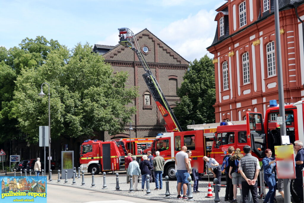 Ein Blick auf ausgestellte Feuerwehrautos im Schatten der Abtei.